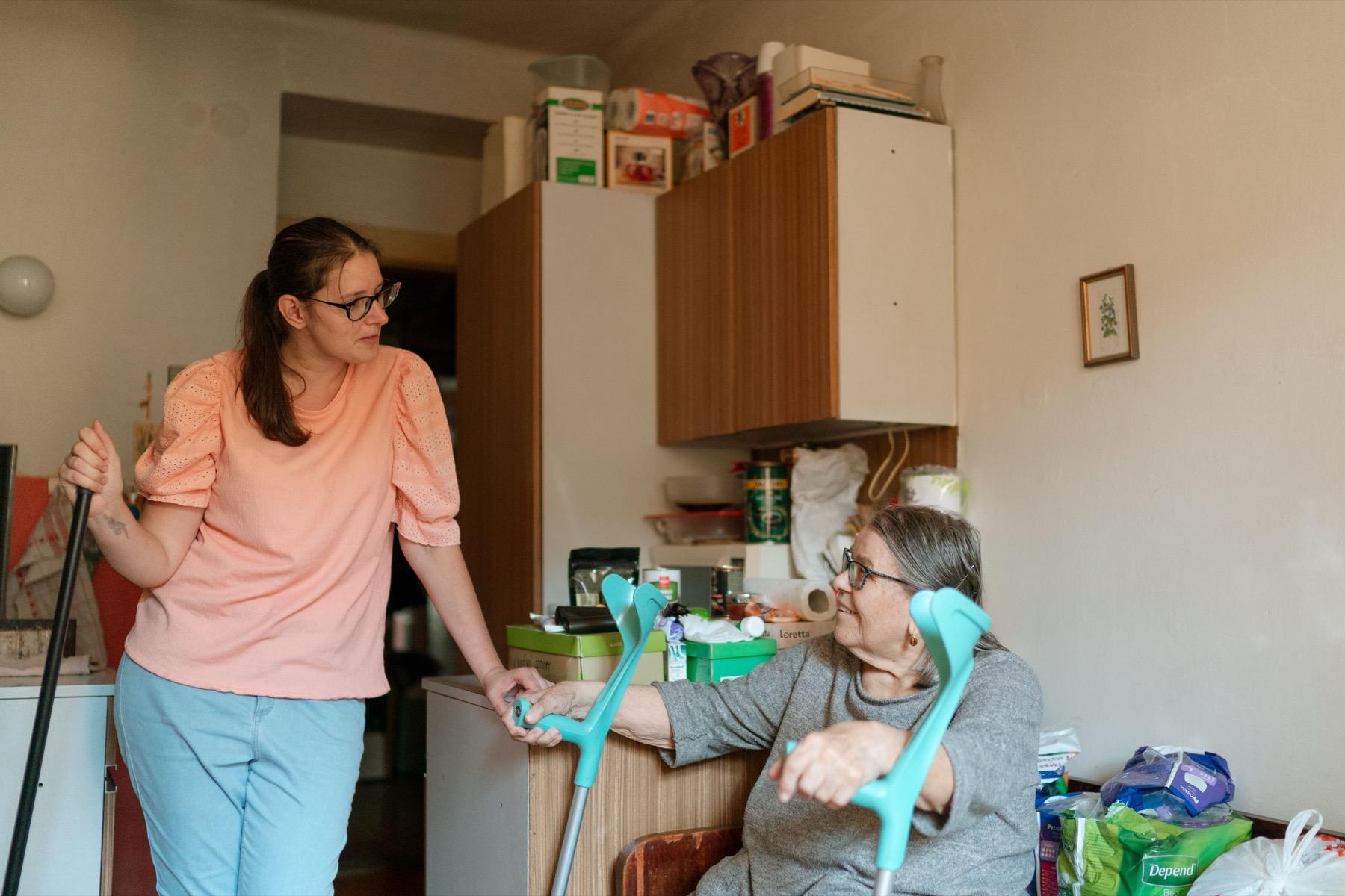 Caregiver supporting an older adult with mobility at home